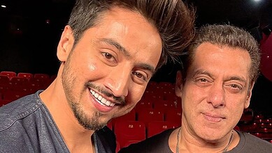 Mr Faisu with an older man at a red-carpet event, smiling for the camera.