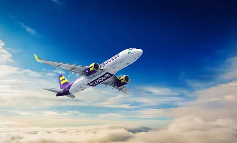 Flyadeal plane flying high above clouds with blue sky background.