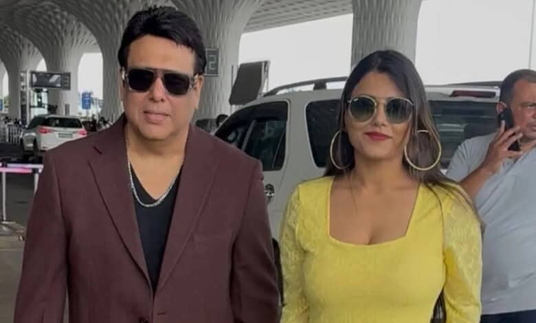 Govinda and Komal Sharma at an airport, both wearing sunglasses and casual attire.
