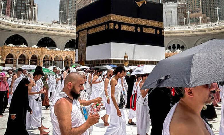 Pilgrims in white ihram clothing at Masjid al-Haram for Hajj pilgrimage.