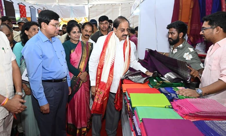 Officials and visitors at the handloom exhibition viewing colourful fabrics and textiles.