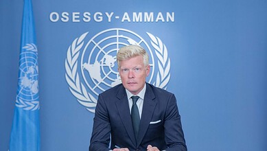 UN envoy speaking at a press conference with UN emblem in the background in Yemen.