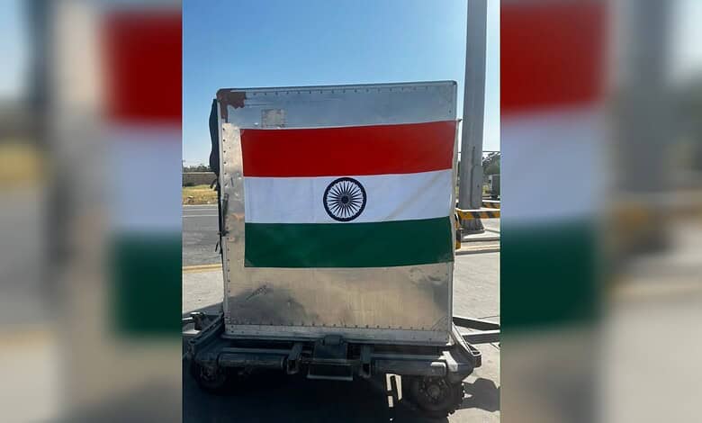 Indian flag painted on a metal road barrier in an outdoor setting.