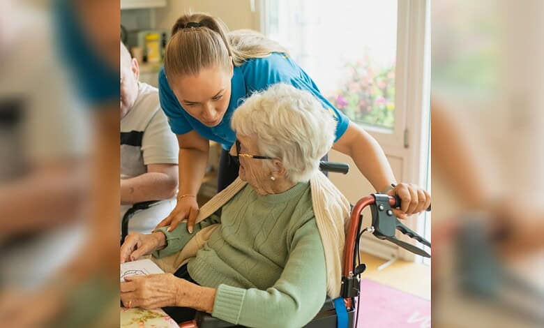 Caregiver helping elderly woman in a wheelchair at home, showing compassion and support.