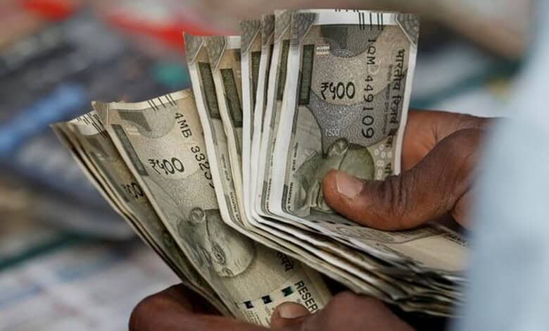Close-up of Indian Rupees being held, symbolising financial dealings and currency exchange.