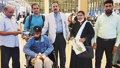 Indian worker with colleagues at airport after returning from Saudi Arabia.