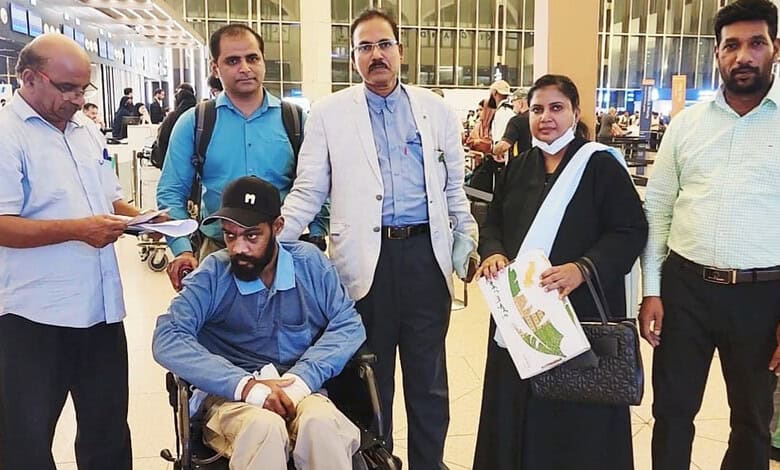 Indian worker with colleagues at airport after returning from Saudi Arabia.