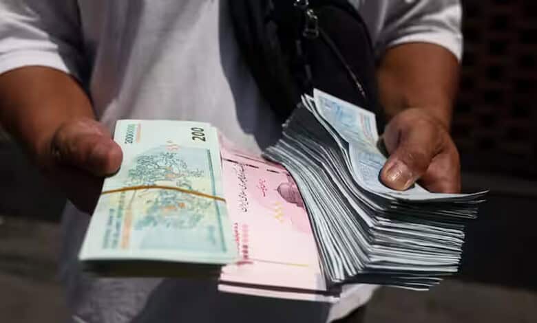 Person holding a large stack of Iranian rial banknotes, indicating currency devaluation.