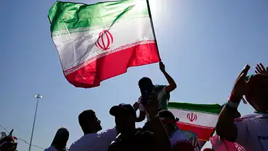 People hold Iranian flags during a gathering.