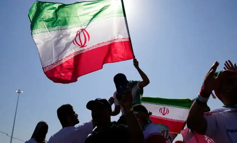 People hold Iranian flags during a gathering.