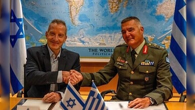 Amir Baram and Ioannis Bouras shake hands after signing the Israeli systems deal with Greece.