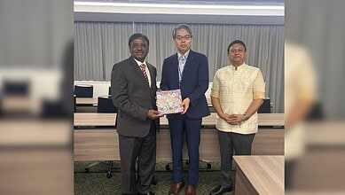 Three men in formal attire at a partnership event with Japan Institution for Young India Skills.