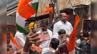 Politicians and supporters celebrating Independence Day with Indian flags at Begum Bazar.