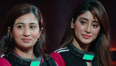 Two women with microphones at an event, smiling and looking to the side.