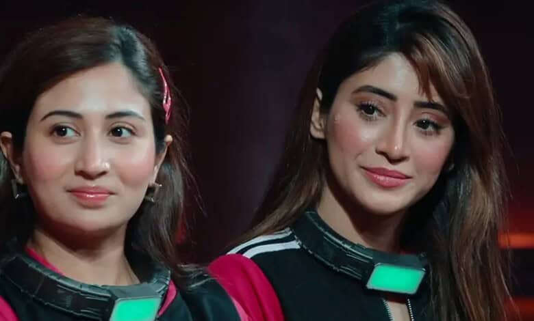 Two women with microphones at an event, smiling and looking to the side.