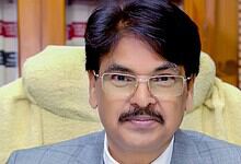 Portrait of BCI Chairman with glasses and mustache in office setting.