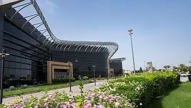 Contemporary airport building with glass facade and landscaped surroundings.