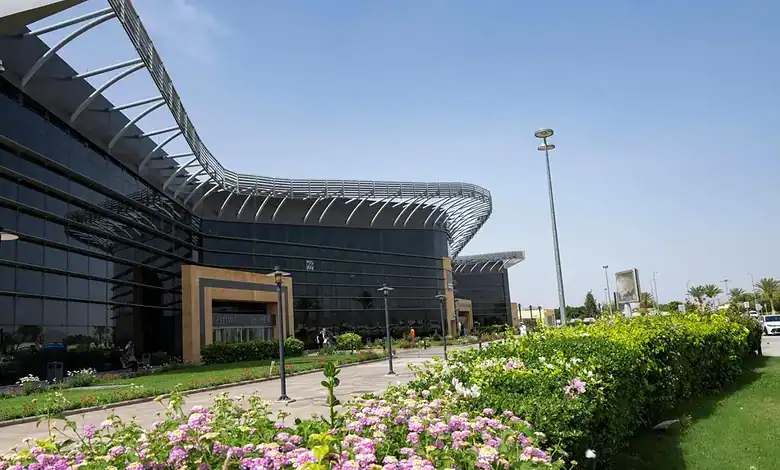 Contemporary airport building with glass facade and landscaped surroundings.