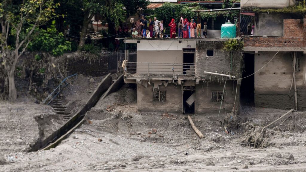 People gather on the roof of a precarious house after flash floods, at the Devighat in Bidur, Nuwakot, Nepal, Thursday, Aug. 27, 2026. The death toll from the devastating flash floods surged to 359 on Thursday. (PTI Photo/Abhishek Maharjan)
