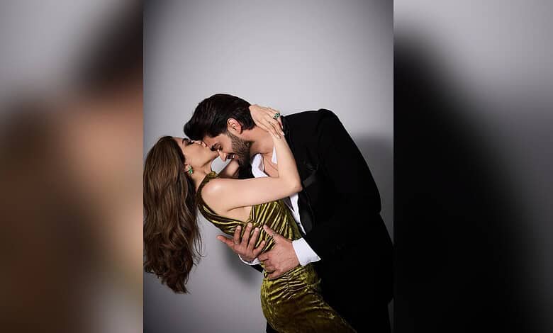 A couple in formal attire sharing an intimate moment, smiling and touching foreheads.