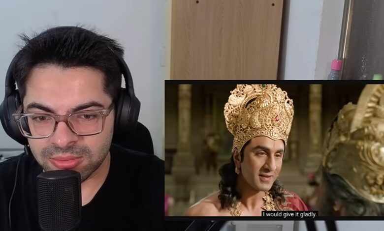 YouTuber recording a reaction video to Ramayana trailer with headphones and microphone.