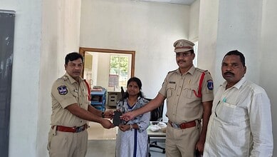 Police officer handing over an award to a girl in an office setting with two other men present.
