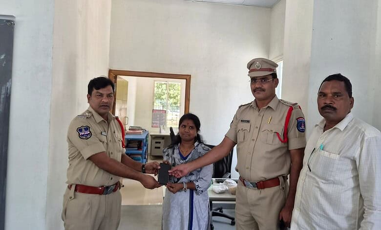 Police officer handing over an award to a girl in an office setting with two other men present.
