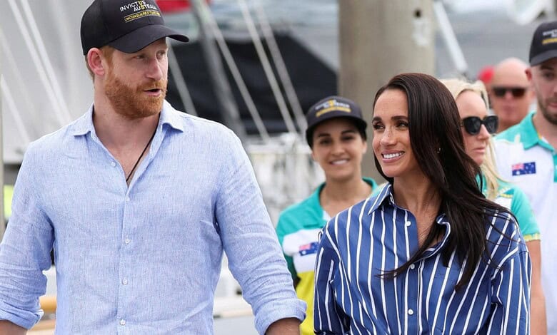 Prince Harry and Meghan smiling and walking at the marina with friends and family.