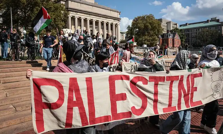 Pro-Palestine protesters holding a large Palestine banner during demonstration in Berlin.