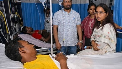 Jharkhand Agriculture Minister Shilpi Neha Tirkey interacts with a protester who was admitted to a hospital after falling ill during an indefinite hunger strike, in Ranchi, Wednesday, Aug. 12, 2026