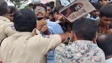 Police officers confront students during a protest in Mahabubabad, grabbing a student's throat.