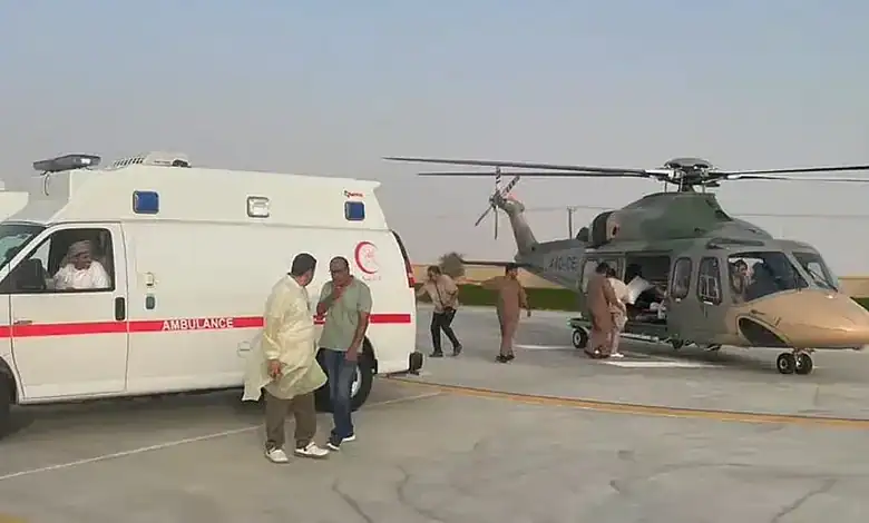 Ambulance and helicopter at Oman road accident site with rescue personnel.