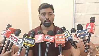 Congress MLA's son speaks to media amid multiple microphones at press conference.
