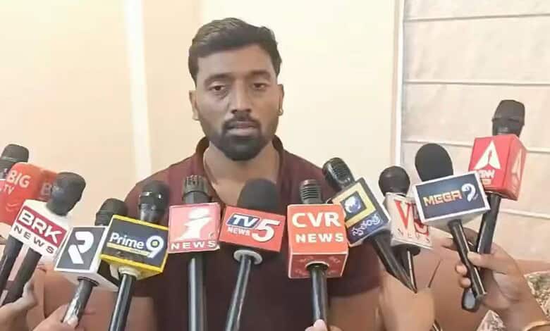 Congress MLA's son speaks to media amid multiple microphones at press conference.
