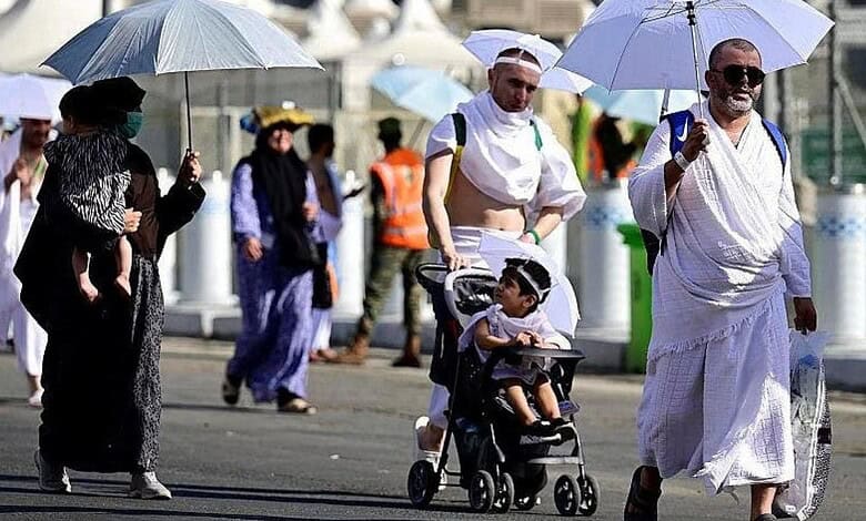 Pilgrims in Mecca using umbrellas to shield from the sun during Hajj.