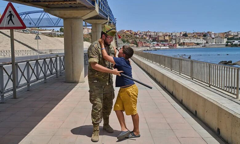 A 12-year-old unaccompanied minor who crossed into Spain is escorted by a Spanish soldier to the Spain-Morocco border as the child begs not to be sent back to Morocco from the Spanish enclave of Ceuta, Monday, Aug. 3, 2026. The forced deportation of the unaccompanied minor was stopped by a high-ranking official a few meters before the child reached the border after residents and journalists said the migrant was a minor. (AP Photo/Bernat Armangue)