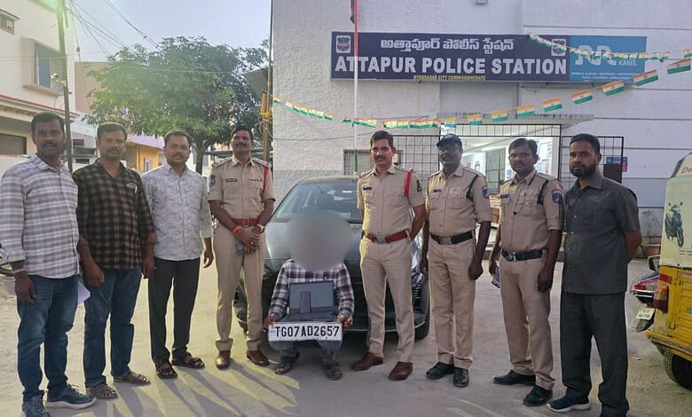 Group of police officers and civilians outside Attapur Police Station with a seized vehicle.