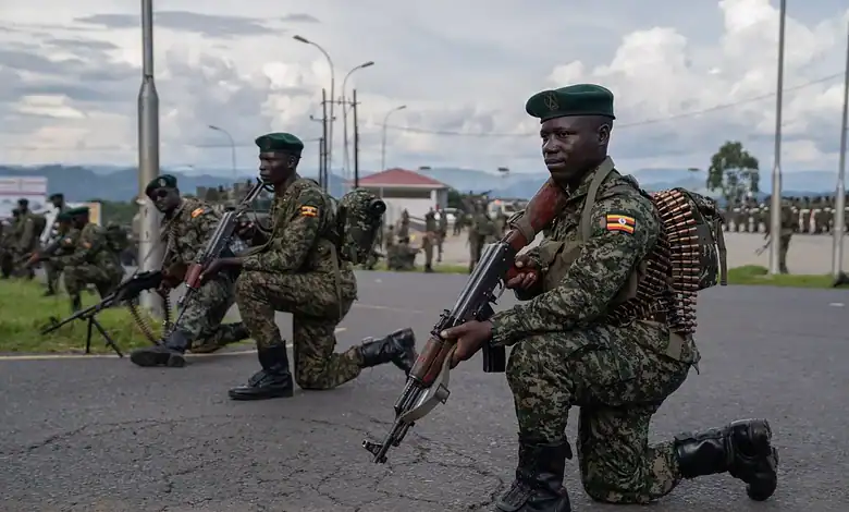 Ugandan soldiers kneel with rifles during a military deployment exercise, as parliament approves the country's participation in an international force planned for Gaza.