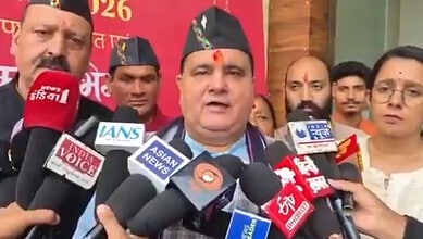 Uttarakhand BJP leader addresses media amid multiple microphones at a political rally.