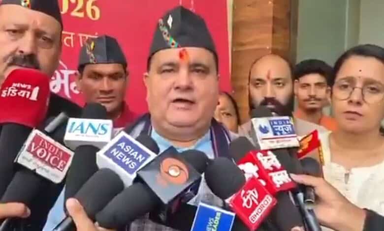 Uttarakhand BJP leader addresses media amid multiple microphones at a political rally.