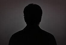 Silhouette of a Bollywood actor against a dark background, emphasizing mystery and fame.
