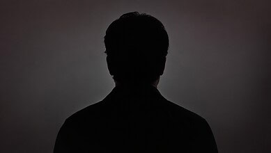 Silhouette of a Bollywood actor against a dark background, emphasizing mystery and fame.