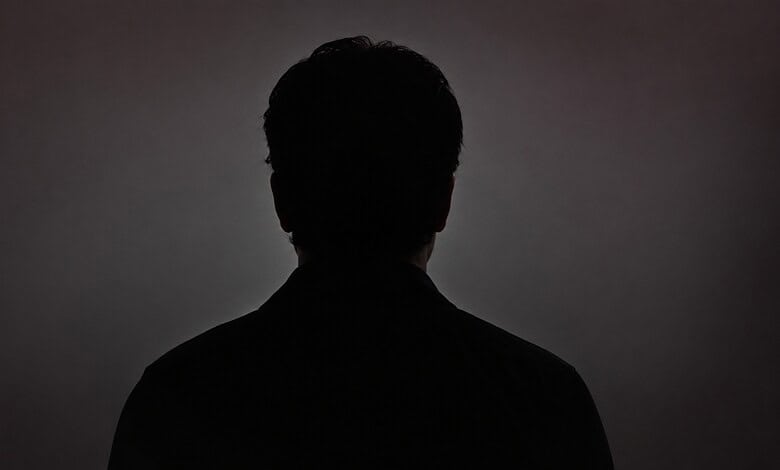 Silhouette of a Bollywood actor against a dark background, emphasizing mystery and fame.