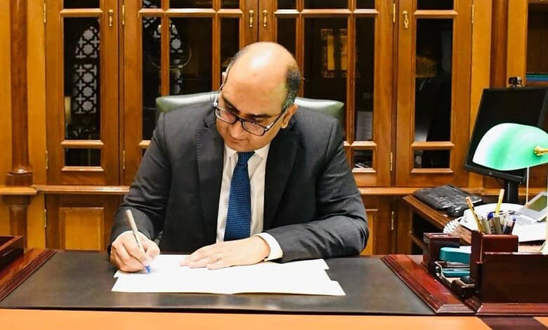 Vipul signs documents at his desk.