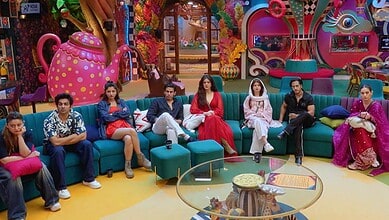Bigg Boss 20 contestants sitting on colourful sofas in the house.