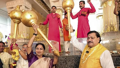 Celebration of PM Modi's birthday with large golden maces at a temple in India.