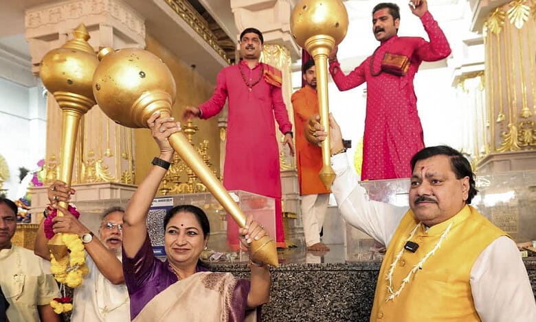 Celebration of PM Modi's birthday with large golden maces at a temple in India.