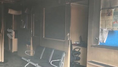 Inside HDFC bank showing burnt furniture and damaged interior after fire.