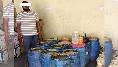 Man standing near large blue containers of suspected adulterated ginger-garlic paste in a room.