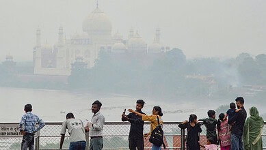 Agra Tourists view the Taj Mahal across the Yamuna river as cloudy weather keeps the sky hazy, in Agra, Uttar Pradesh, Friday, Aug. 14, 2026.